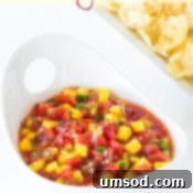 Small bowl of mango salsa with a chip