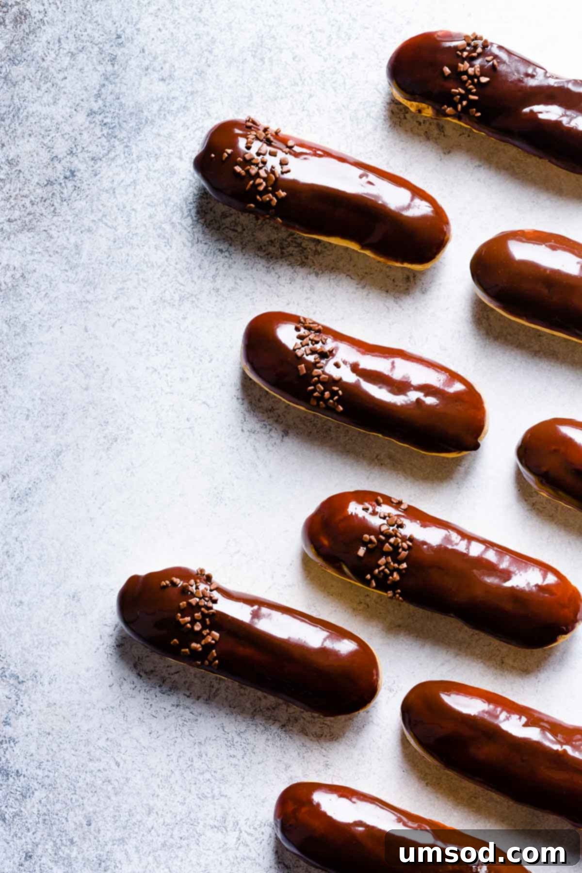 Decadent Chocolate Eclairs 13 An overhead shot of a batch of freshly baked chocolate eclairs, perfectly glazed and ready for serving.