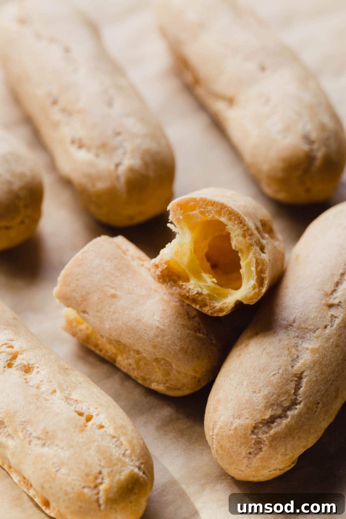 Decadent Chocolate Eclairs 9 An inviting arrangement of freshly baked eclair shells, some already filled, waiting for their chocolate glaze.