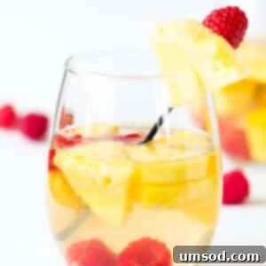 A glass of Pineapple Raspberry Sangria, showcasing the vibrant colors and fresh fruit