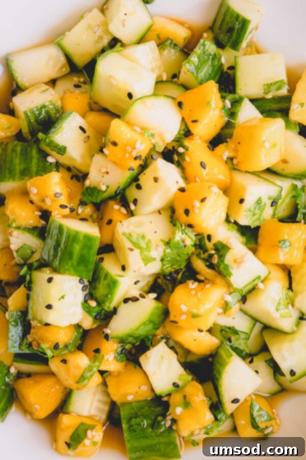 Upclose shot of vibrant cucumber mango salad, highlighting the fresh ingredients.