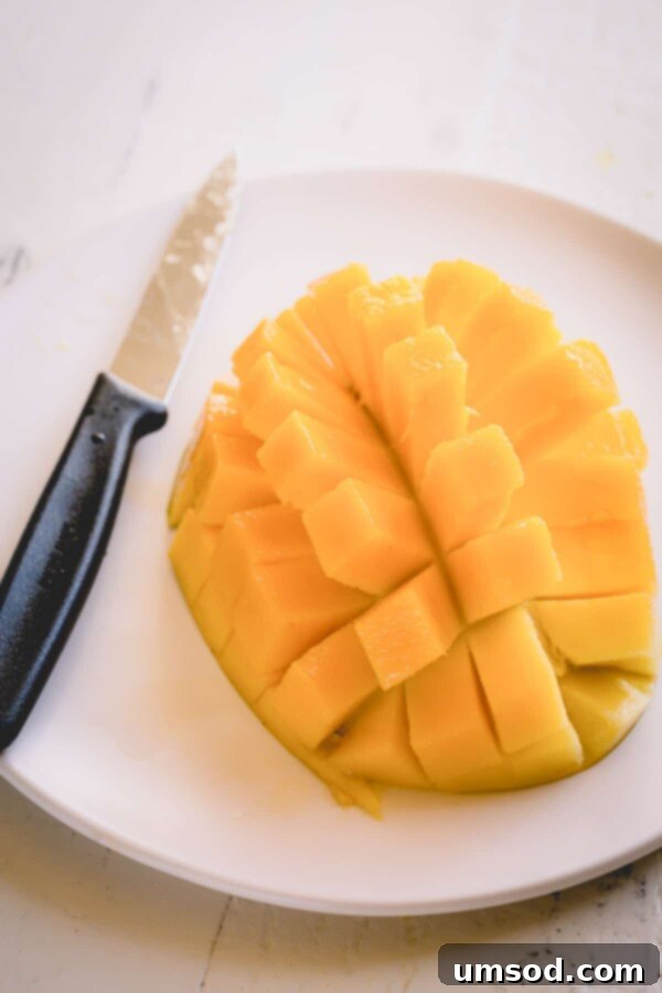 Mango half sliced into a grid pattern, ready for cubing.