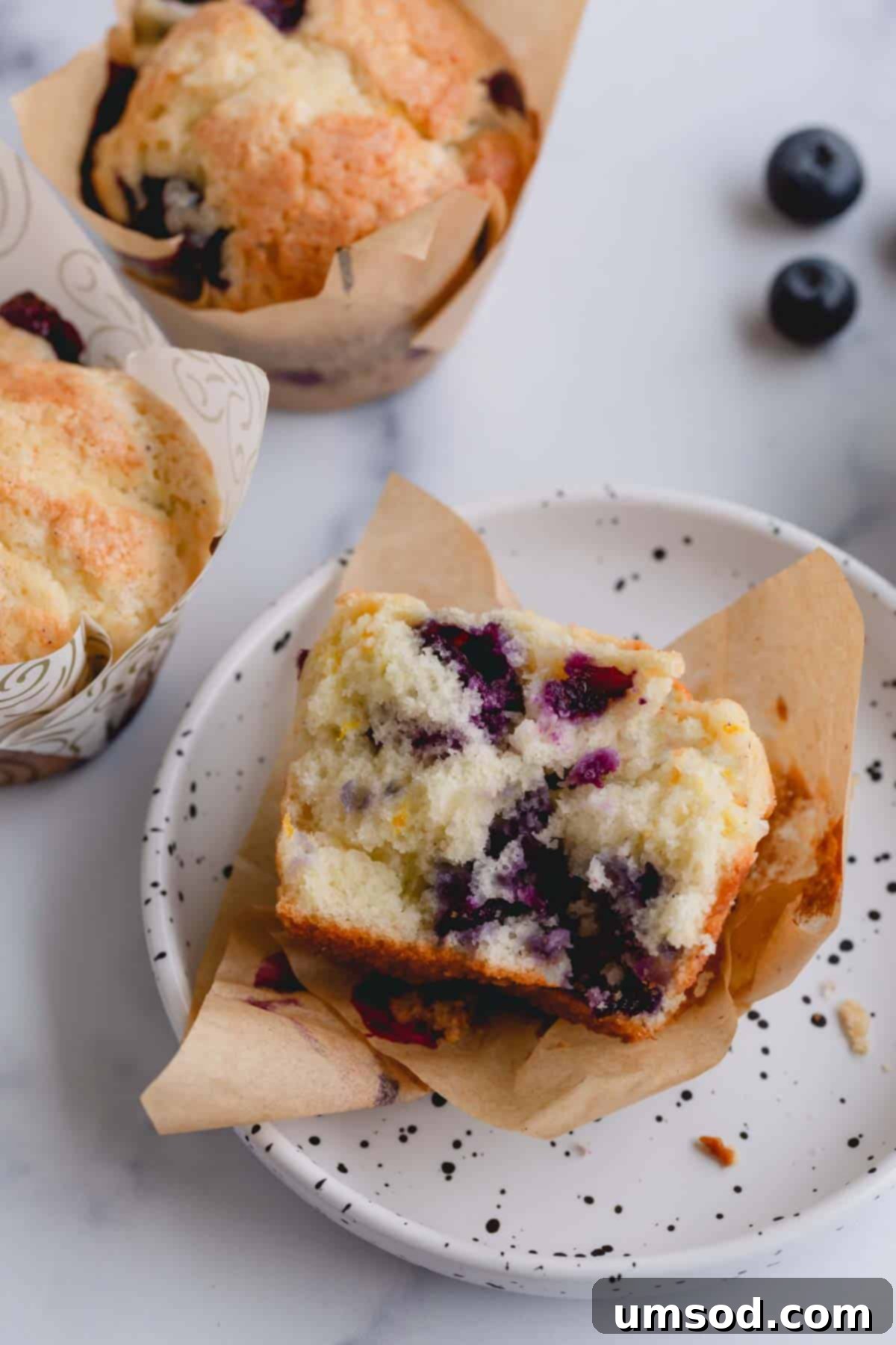Blueberry Cheesecake Swirl Muffins 9 Half a blueberry cheesecake muffin on a small plate, showing the swirl inside.
