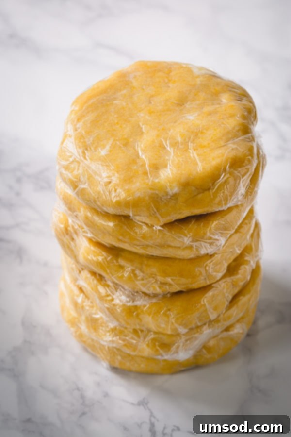 A stack of six neatly wrapped pie dough discs, illustrating efficient storage.
