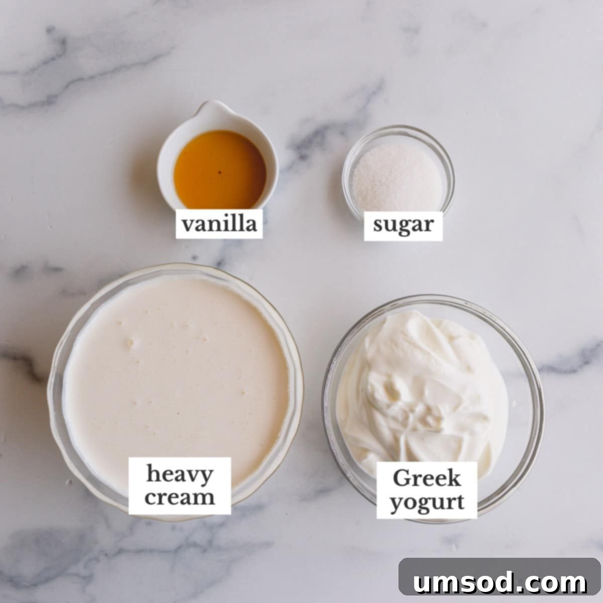 The essential ingredients for homemade yogurt whipped cream: heavy cream, Greek yogurt, sugar, and vanilla extract, neatly arranged.