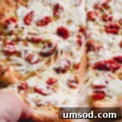 Slow-Roasted Tomato and Melted Cheese Pizza 10 sliced pizza with cheese pull.