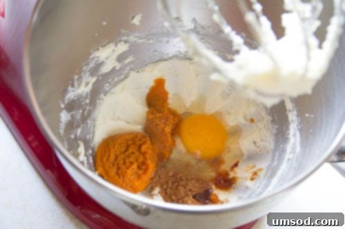 Mixing butter, sugar, pumpkin puree, egg, flour, vanilla, and pumpkin pie spice for the creamy pumpkin croissant filling.