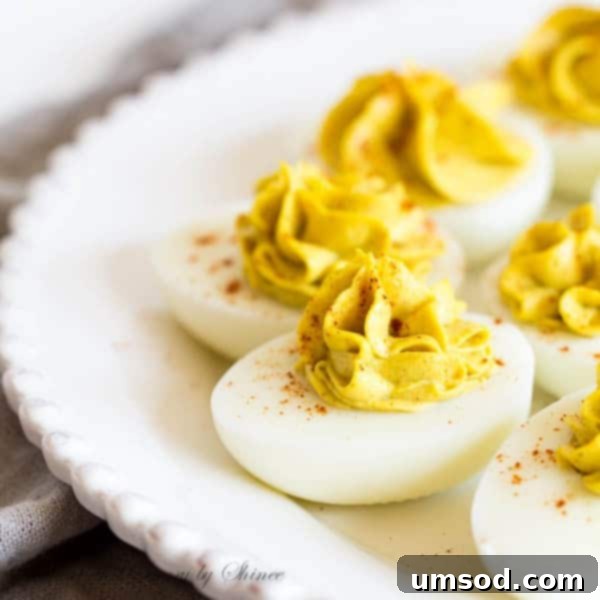 Golden Curry Deviled Eggs 4 A spoon mixing the creamy, golden curry deviled egg filling in a bowl.
