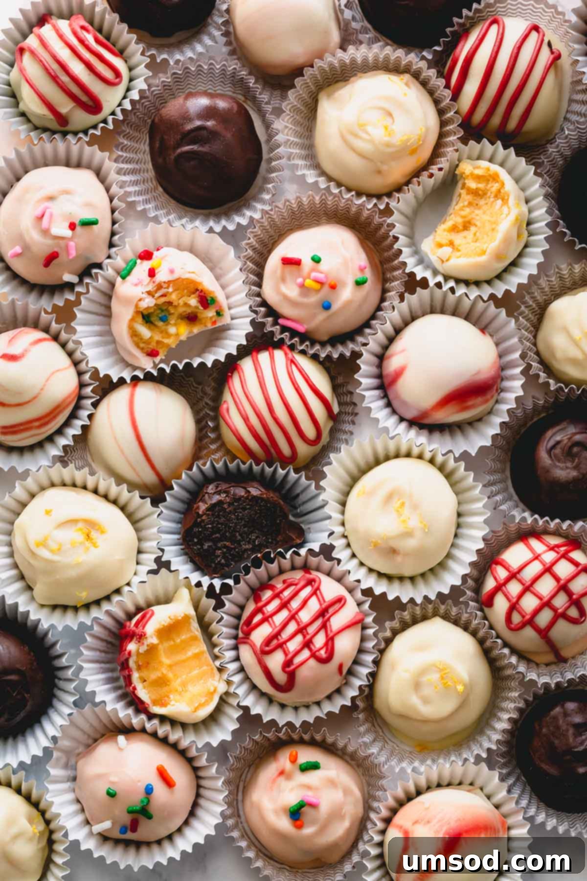 Colorful Oreo balls neatly placed in mini cupcake liners on a serving tray, showcasing various decorations.