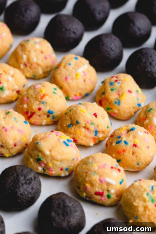 Uncoated funfetti Oreo balls, speckled with colorful sprinkles, ready for their final chocolate dip.