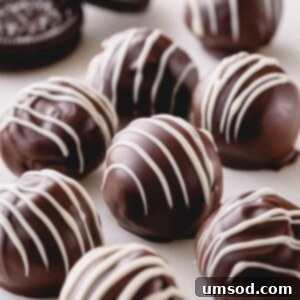 Dark chocolate Oreo balls with white chocolate drizzle.