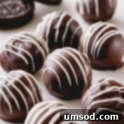 Dark chocolate Oreo balls with white chocolate drizzle.