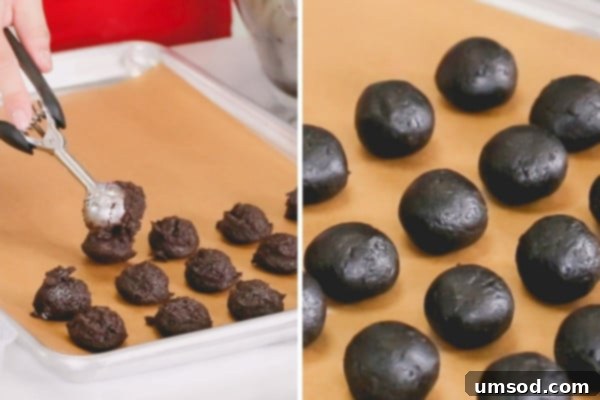A hand shaping a smooth Oreo ball, demonstrating the technique for achieving a perfect sphere.