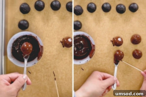 A close-up of an Oreo ball being dipped in melted chocolate using a fork, showing the excess dripping.