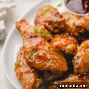 Sticky Teriyaki Chicken Wings 13 A close-up image of oven baked honey teriyaki chicken wings, garnished with sesame seeds and scallions, presented beautifully.