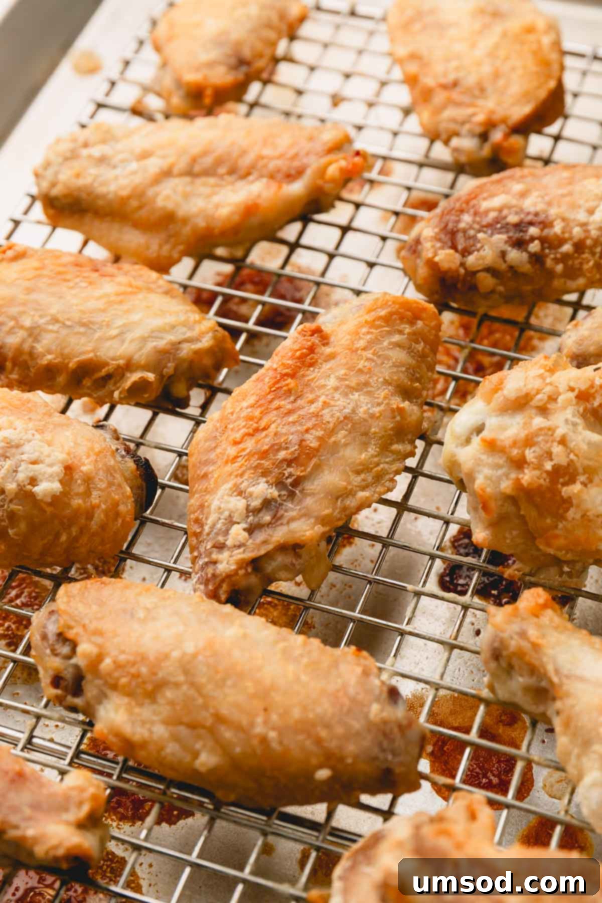 Sticky Teriyaki Chicken Wings 8 Baked chicken wings on a wire rack, golden brown and crispy.