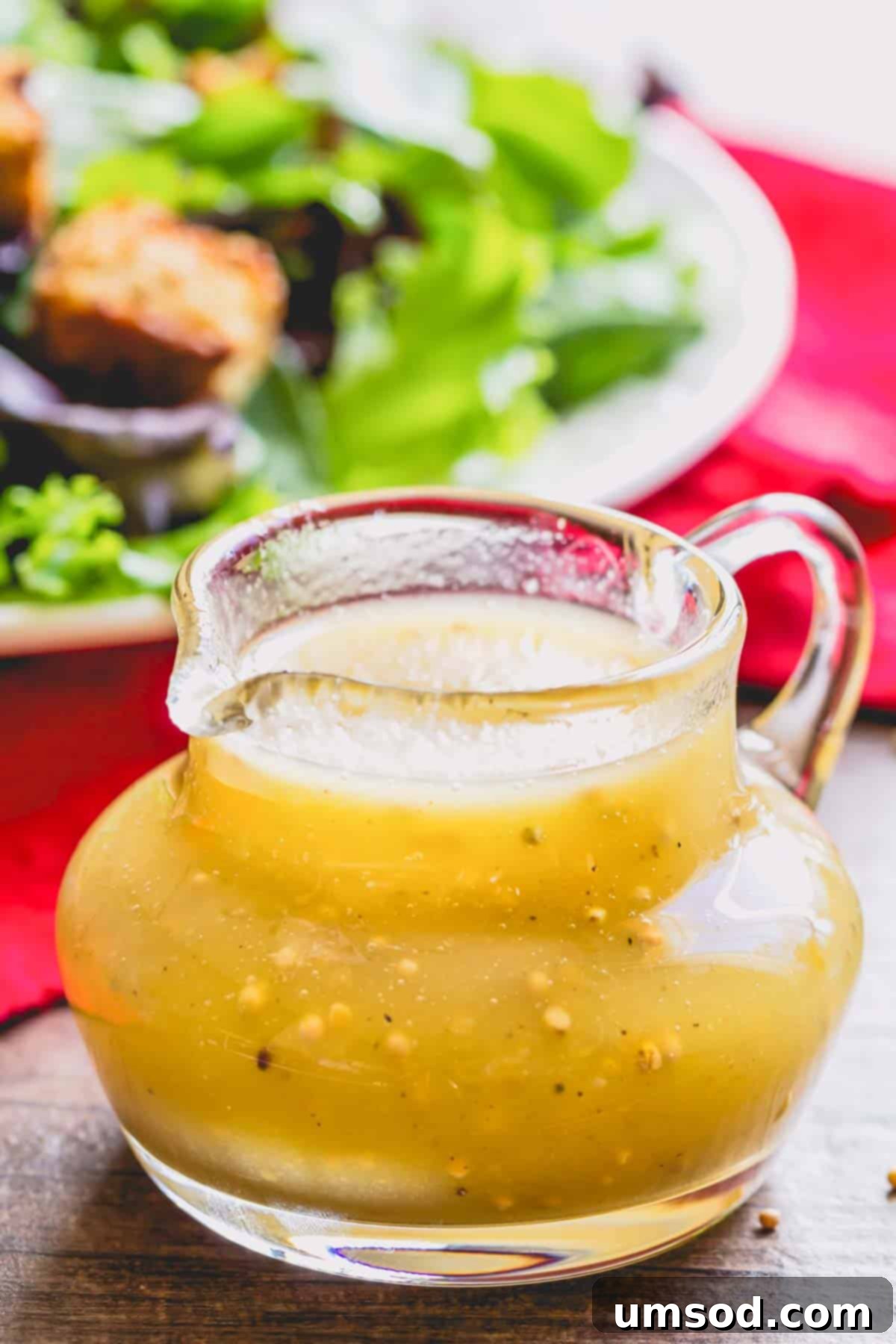 A beautifully presented jar of golden homemade Honey Dijon dressing, ready to be served.