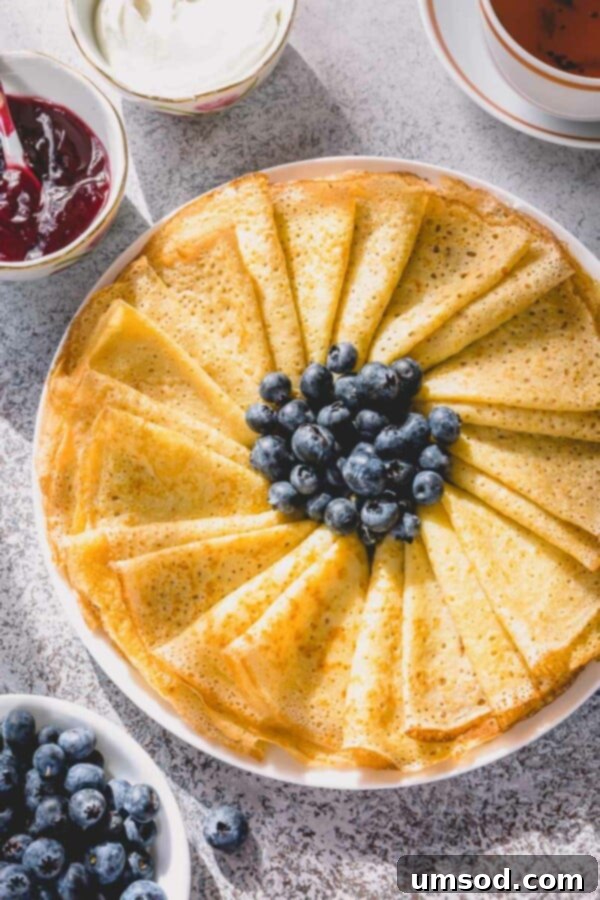 Stack of freshly made thin, lacy crepes ready to be served.