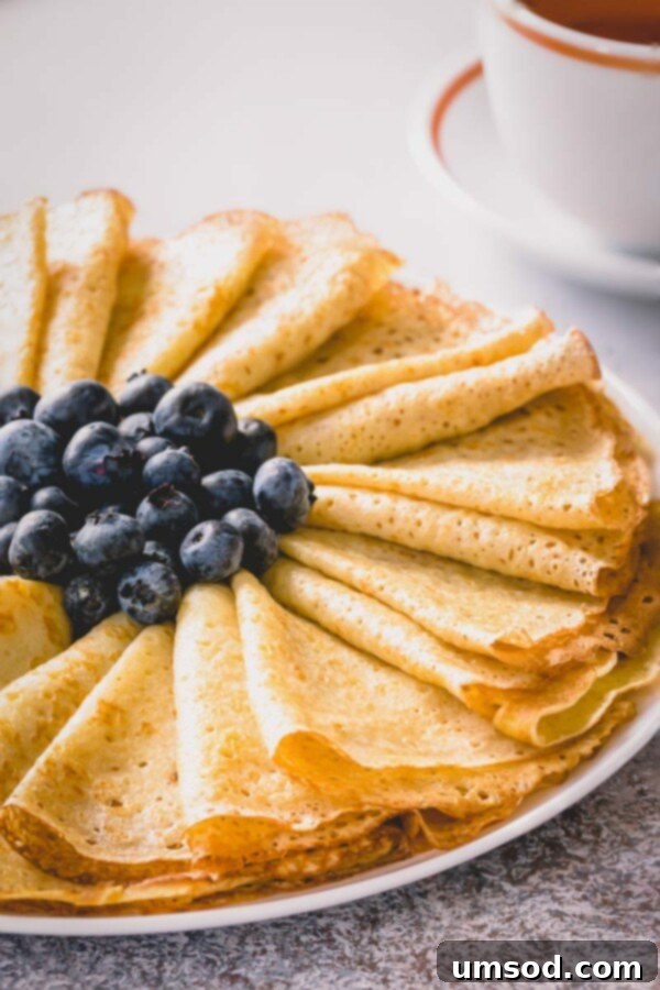 Close-up of crepe batter being poured into a pan.