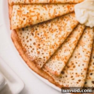 Finished stack of crepes with a dusting of powdered sugar.