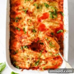 A dish of pesto ricotta stuffed pasta shells with a spoon scooping up a shell, ready for serving.