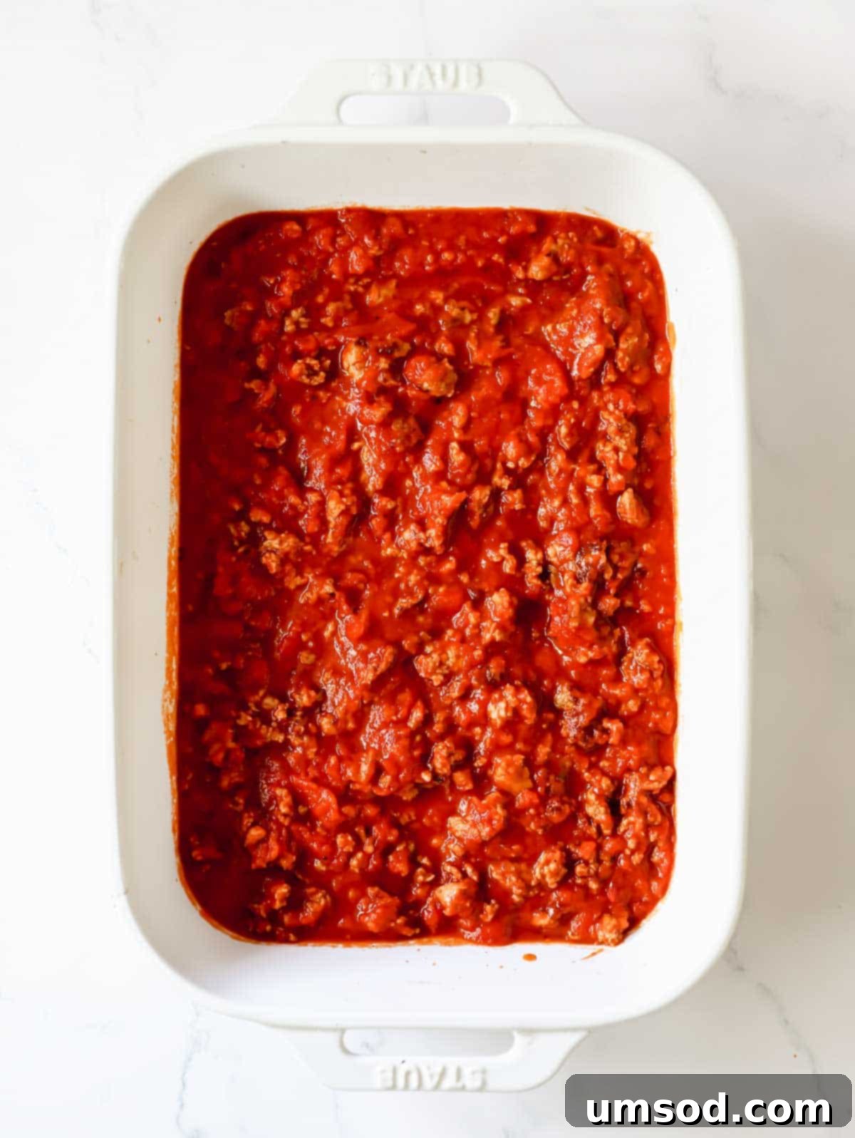 The savory meat sauce spread evenly in a 9x13 inch baking dish, ready for the stuffed shells.