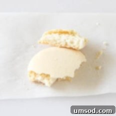 Decoding Macaron Dilemmas 9 A macaron shell broken in half, showing a thin, crispy interior.