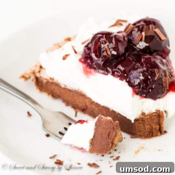 Cherry Chocolate Pavlova with a spoonful of cherry sauce being added