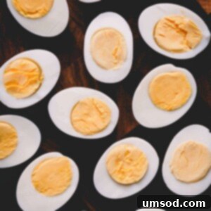 Halved hard-boiled eggs on a cutting board, perfect for a recipe card visual.