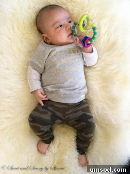 Three Months of Milestones with Baby Grant 5 Close-up of baby Grant happily holding and playing with a colorful toy, exploring its textures