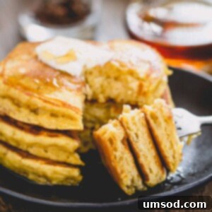 Pillowy Pumpkin Pancakes 7 Stack of 3 pancakes sliced off on a fork.