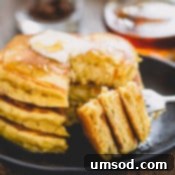 Pillowy Pumpkin Pancakes 8 Stack of 3 pancakes sliced off on a fork.