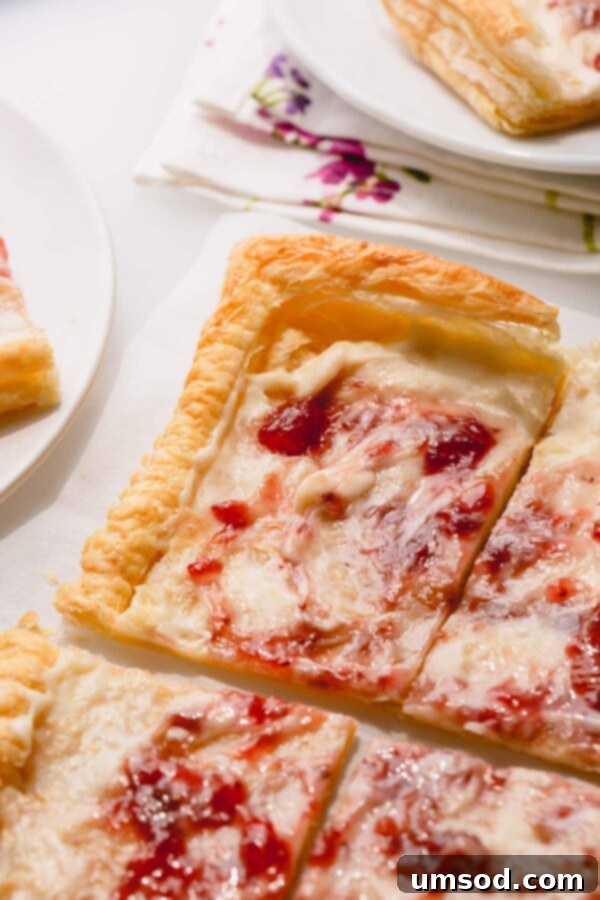 Delicious strawberry cheesecake tart with cream cheese and flaky puff pastry, garnished with fresh strawberries