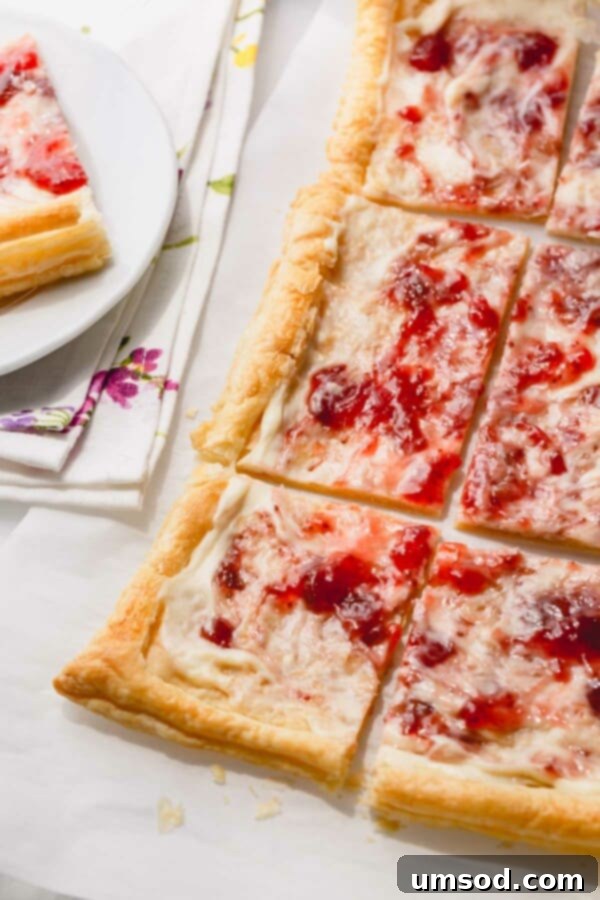 Close-up of the partially baked puff pastry crust, scored and pierced with a fork