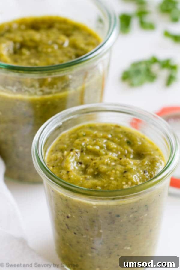 Fire-Roasted Tomatillo Salsa Verde 3 Two glass jars filled with freshly made charred tomatillo salsa verde, ready for storage or serving.