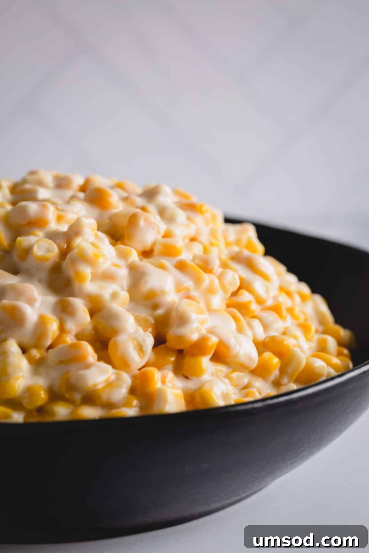 A beautifully presented bowl of creamy homemade creamed corn, garnished and ready to serve.
