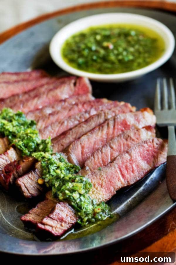 Flawless Ribeye: Grill Perfection with Zesty Chimichurri 2 Perfectly grilled ribeye steak on a cutting board, ready to be sliced, garnished with fresh herbs.
