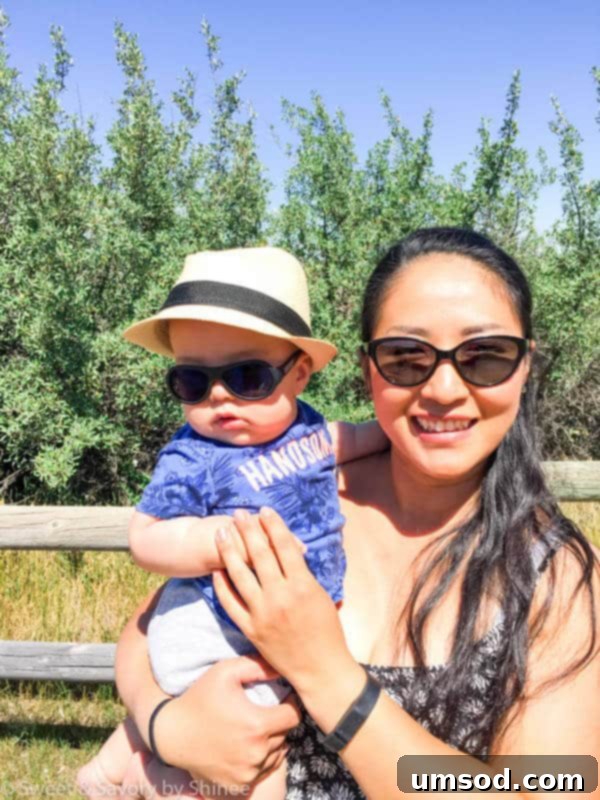 Baby Grant on a colorful playmat, attempting to crawl and reach for toys at 7 months