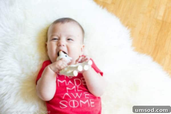 Baby Grant playfully chewing on Sofie de Giraffe teething toy, promoting the #ITsATooth campaign