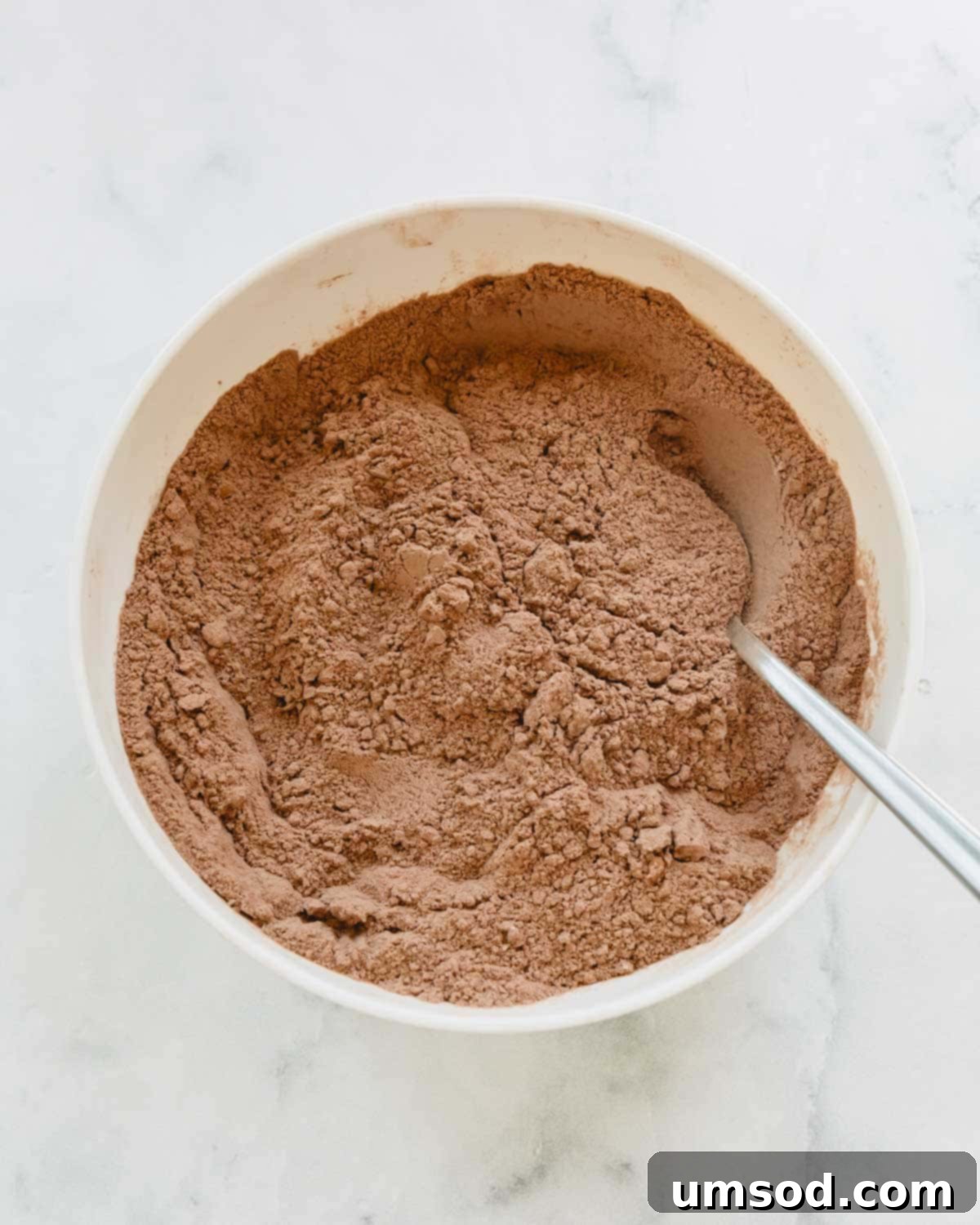 Fudgy Chocolate Zucchini Sheet Cake 4 Dry ingredients for chocolate zucchini cake batter being whisked together in a large bowl.