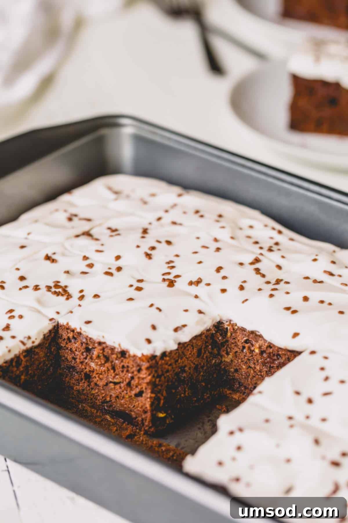 Fudgy Chocolate Zucchini Sheet Cake 9 A delectable double chocolate zucchini cake, with several slices already removed, showing its irresistible moist interior and fudgy texture.