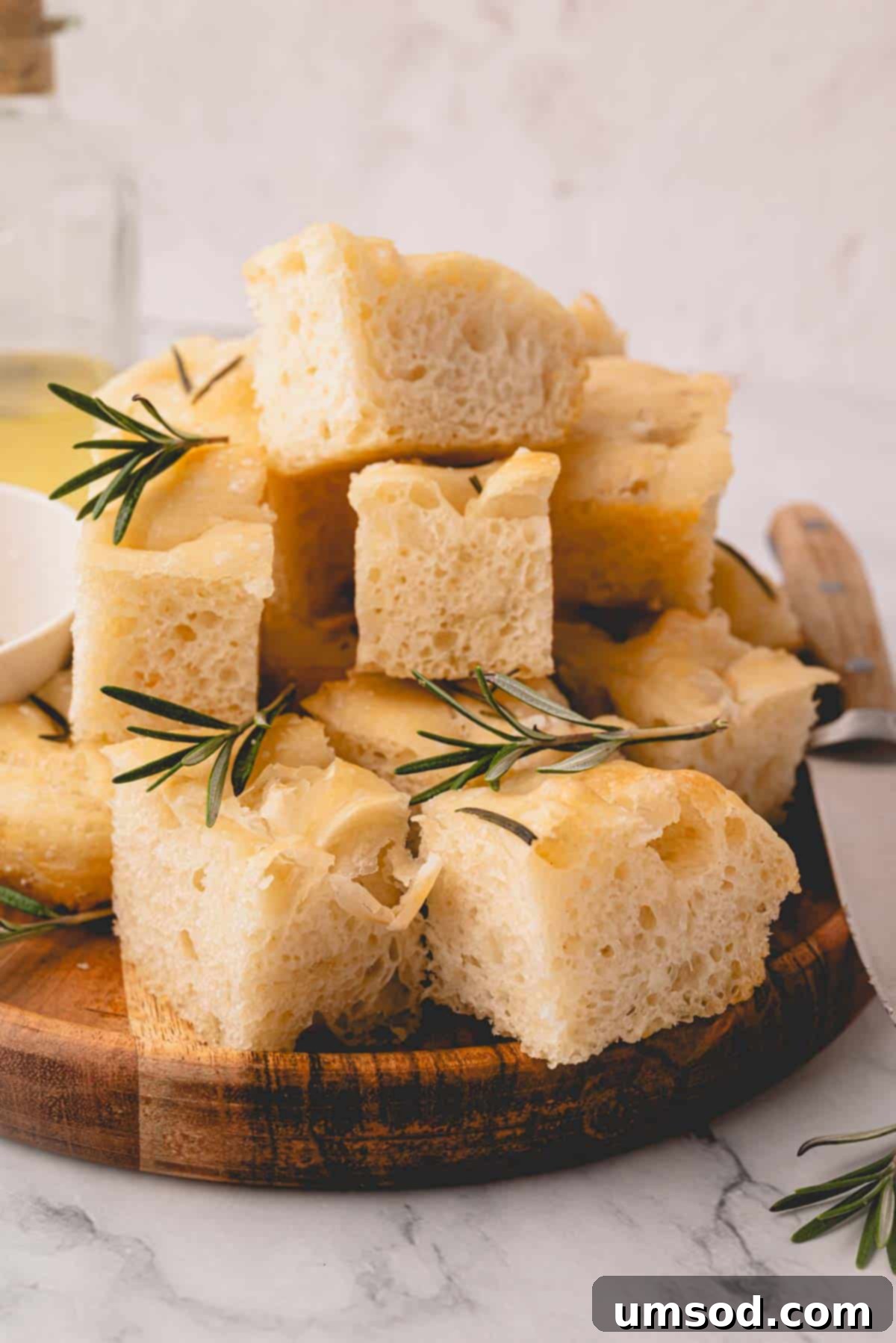 Effortless Homemade Focaccia: A Baker's Delight 3 Rosemary focaccia bread squares on a wooden plate