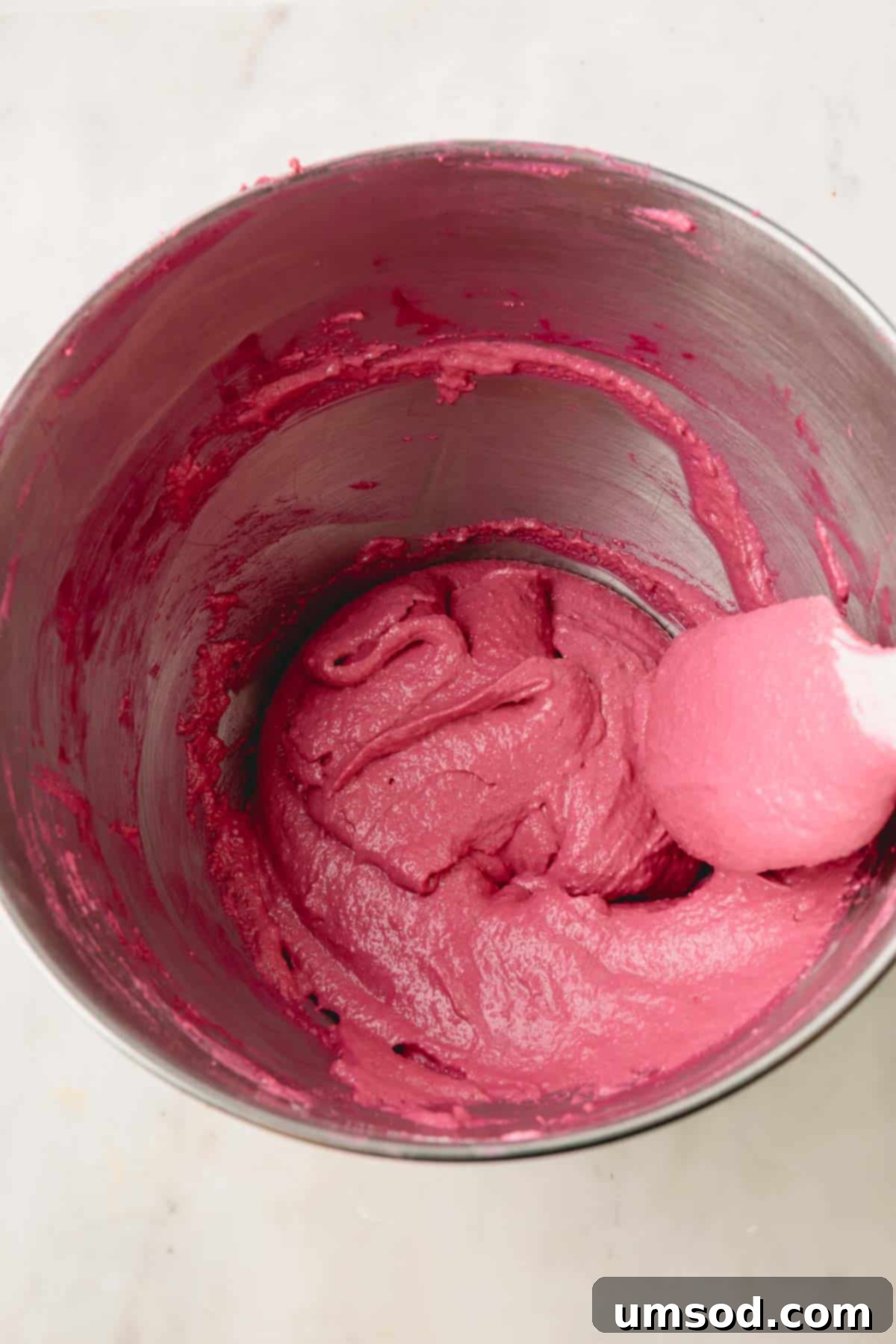 Cranberry Citrus Macarons 13 Close-up of a bowl filled with cranberry macaron batter, ready for piping.