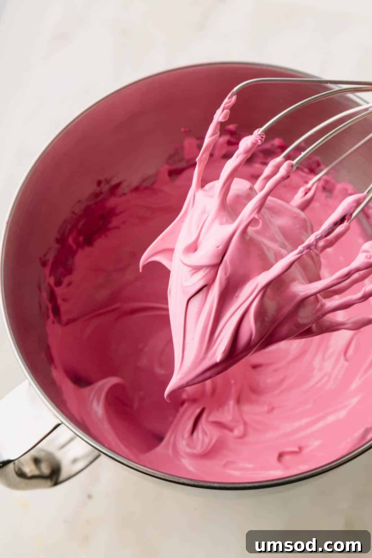 Cranberry Citrus Macarons 10 A bowl of perfectly whipped pink meringue, showing stiff peaks rising from the surface.